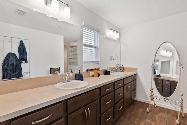 bathroom featuring hardwood / wood-style floors, vanity, and a textured ceiling