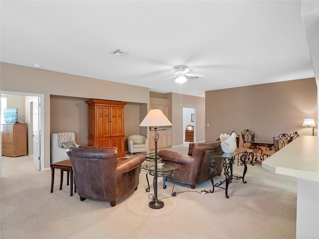 carpeted living room with ceiling fan