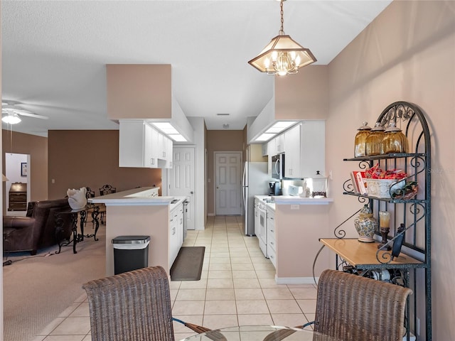 kitchen with light tile patterned floors, appliances with stainless steel finishes, and white cabinets