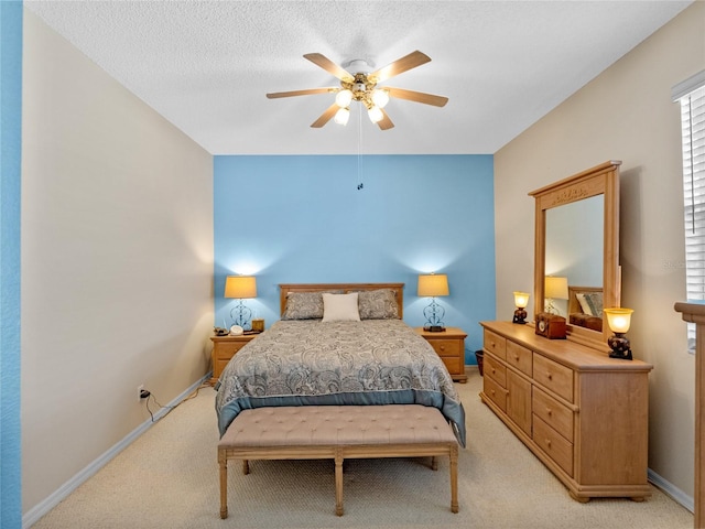 bedroom with light carpet, ceiling fan, and a textured ceiling