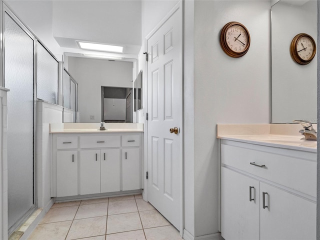 bathroom with a shower with door, tile patterned floors, and vanity