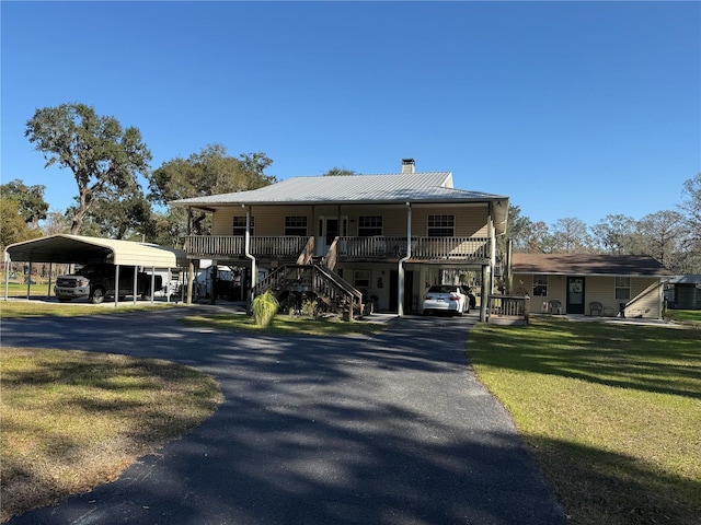 view of front of home featuring a porch, a front yard, and a carport