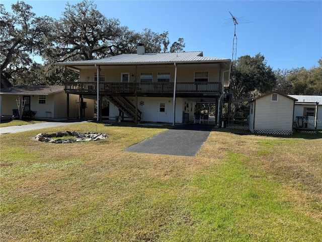 rear view of property featuring a lawn, a carport, and covered porch