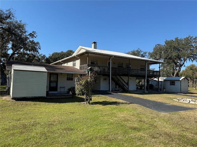 back of property with a yard and a shed