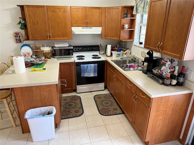 kitchen with electric range, a breakfast bar area, sink, and light tile patterned floors