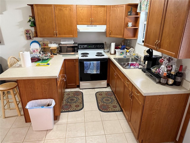 kitchen with kitchen peninsula, electric range, a breakfast bar area, light tile patterned flooring, and sink