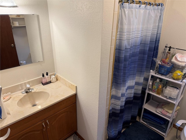 bathroom with curtained shower and vanity