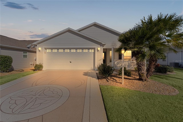 view of front of house featuring cooling unit, a yard, and a garage