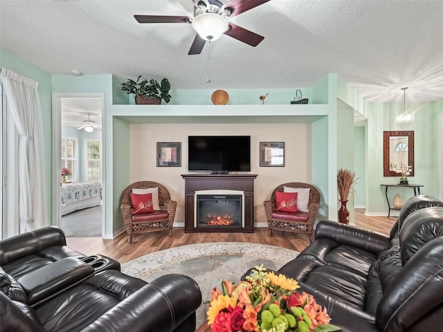 living room featuring hardwood / wood-style flooring, a textured ceiling, and ceiling fan