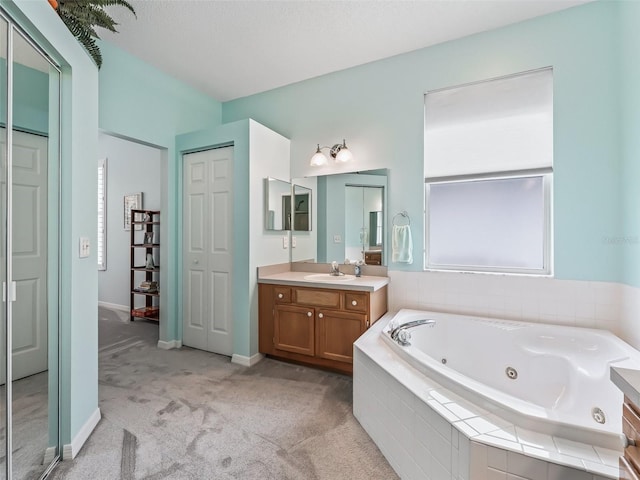 bathroom featuring tiled bath and vanity