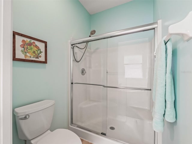 bathroom featuring toilet and an enclosed shower