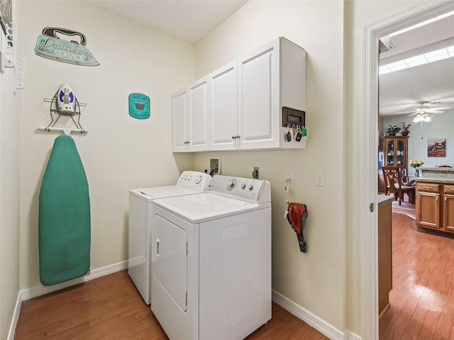 laundry room featuring ceiling fan, cabinets, separate washer and dryer, and light wood-type flooring