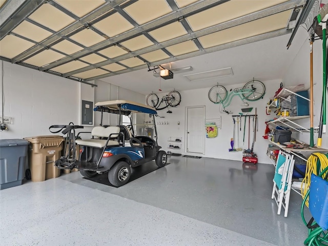 garage featuring a garage door opener, electric panel, and a carport