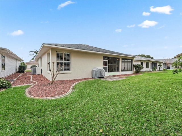 rear view of property featuring a yard and cooling unit