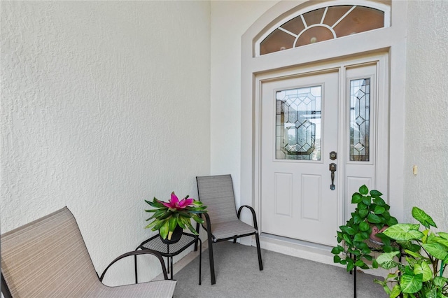 doorway to property featuring stucco siding