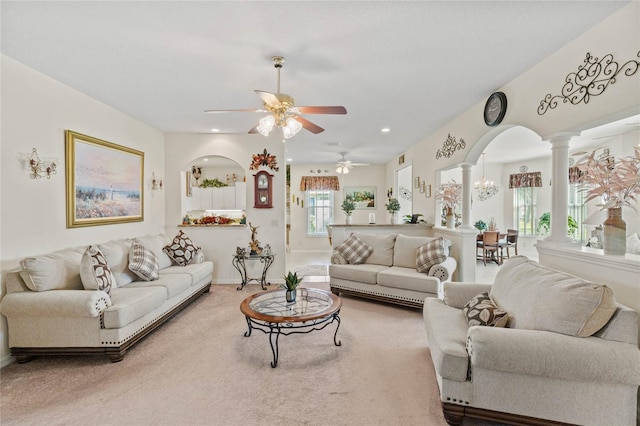 carpeted living room featuring ceiling fan and ornate columns