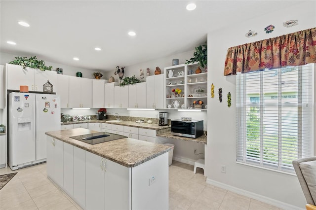 kitchen with sink, white cabinets, a center island, black electric cooktop, and white refrigerator with ice dispenser