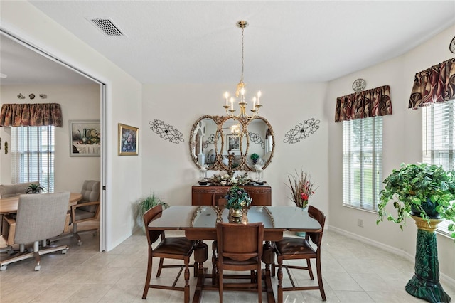 dining space featuring light tile patterned floors and a notable chandelier