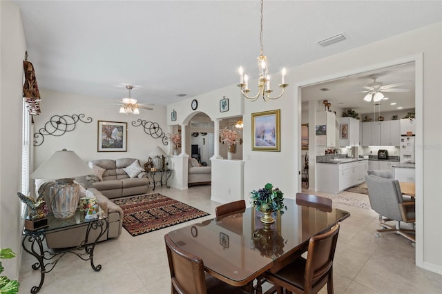 dining space featuring ceiling fan with notable chandelier and light tile patterned floors