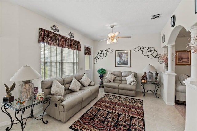 tiled living room with ceiling fan and ornate columns