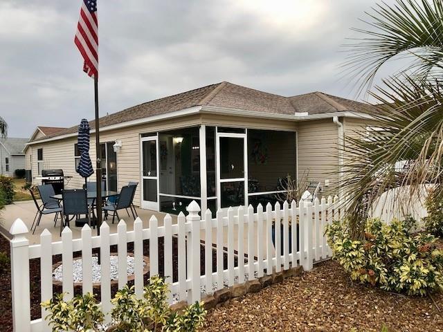 rear view of property featuring a sunroom