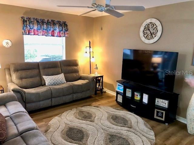 living room with hardwood / wood-style flooring and ceiling fan