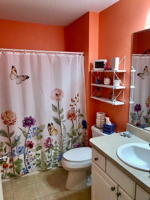 bathroom featuring a textured ceiling, vanity, and toilet