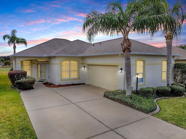 single story home with a lawn and a garage