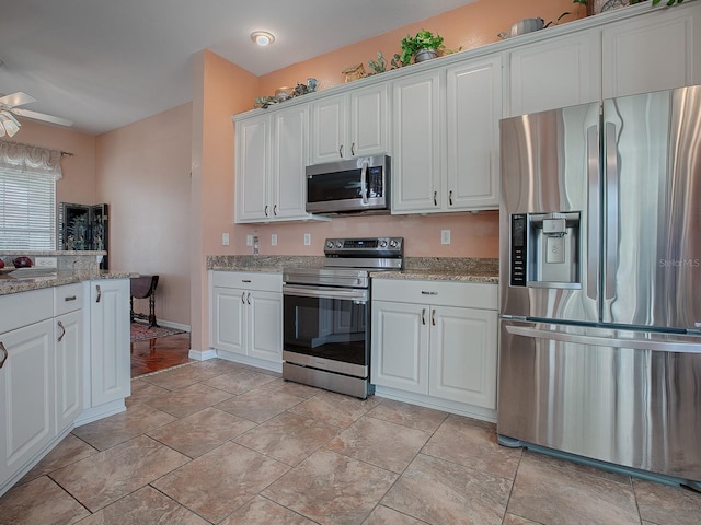 kitchen featuring ceiling fan, light stone countertops, white cabinets, and appliances with stainless steel finishes