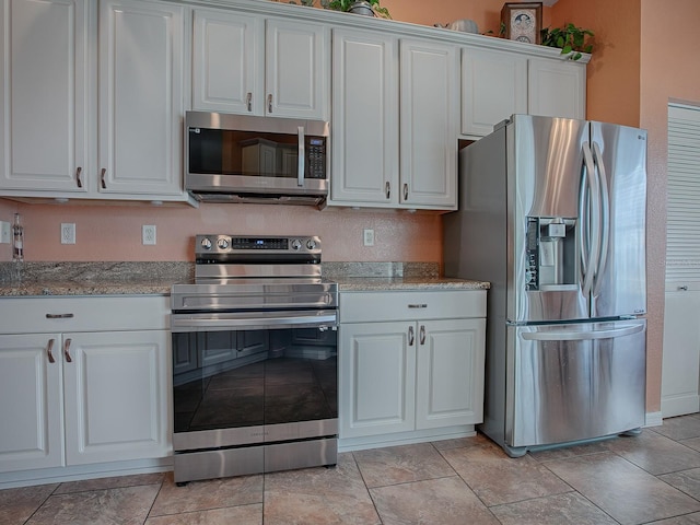 kitchen with light stone countertops, white cabinets, and appliances with stainless steel finishes