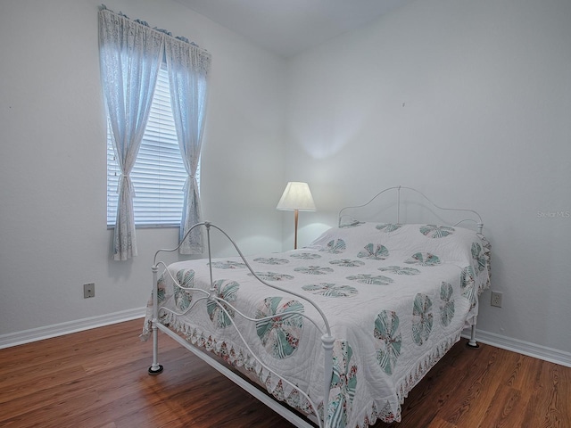 bedroom featuring multiple windows and dark wood-type flooring