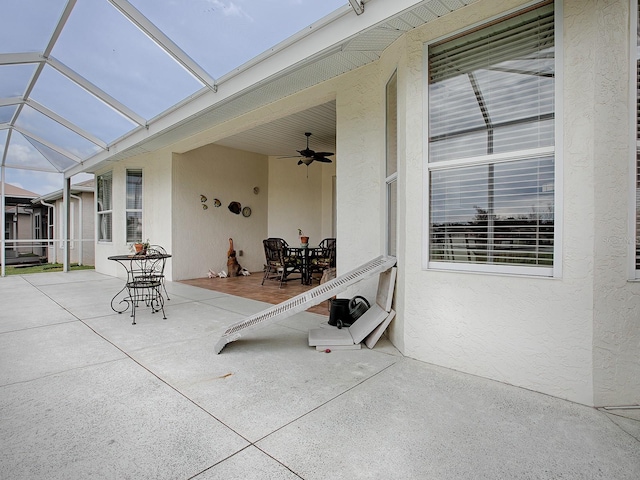 view of patio featuring ceiling fan and a lanai