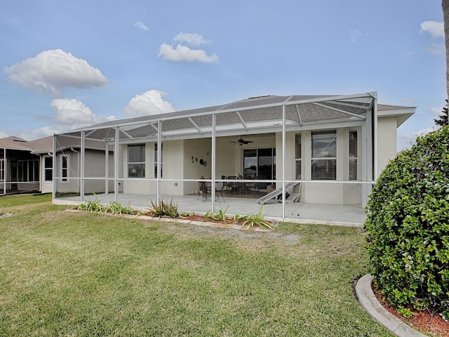 rear view of property with a patio area, a lawn, ceiling fan, and glass enclosure