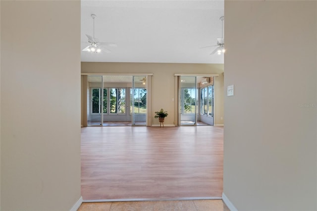 empty room with ceiling fan and light tile patterned flooring