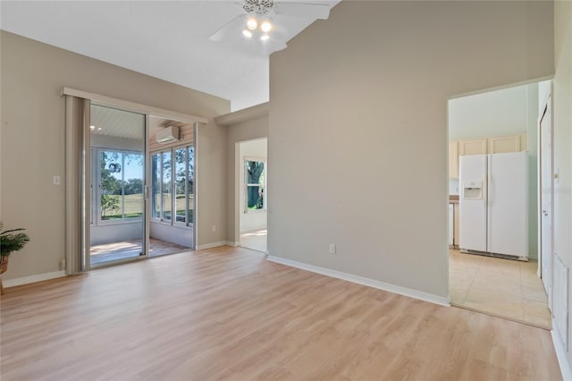 unfurnished room with lofted ceiling, a wall mounted AC, ceiling fan, and light hardwood / wood-style flooring