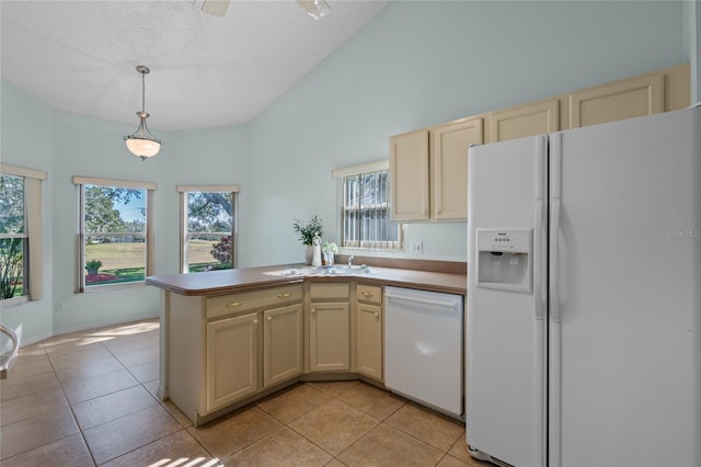 kitchen with white appliances, plenty of natural light, cream cabinetry, and hanging light fixtures