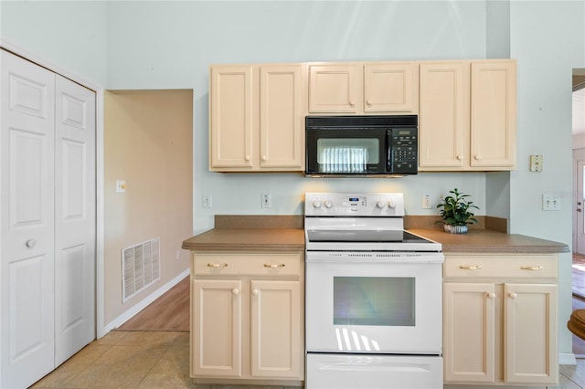 kitchen with electric stove and light tile patterned floors