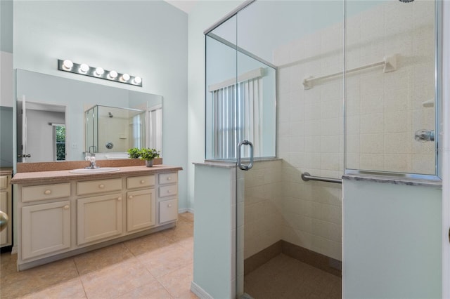 bathroom with vanity, a shower with door, and tile patterned flooring