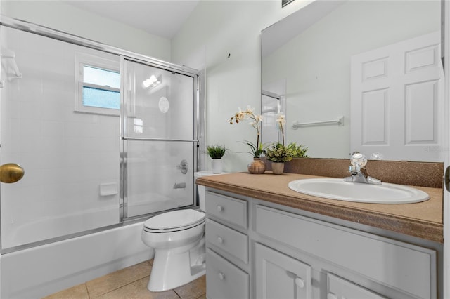 full bathroom with vanity, shower / bath combination with glass door, tile patterned floors, and toilet