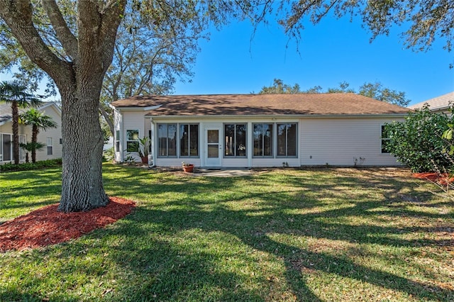 rear view of property featuring a lawn