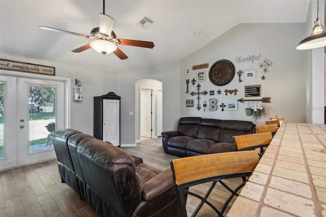 living room featuring french doors, ceiling fan, and vaulted ceiling