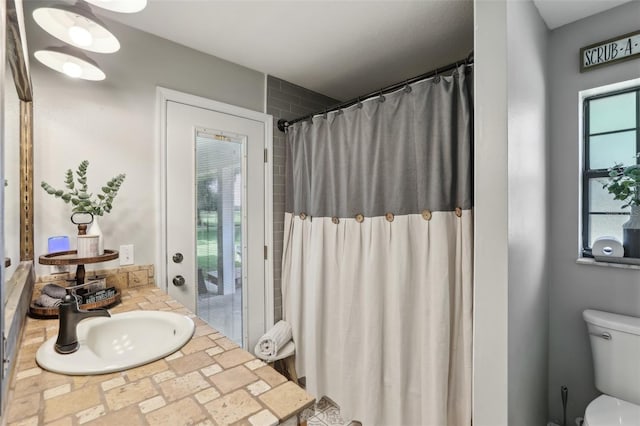 bathroom with toilet, vanity, and curtained shower