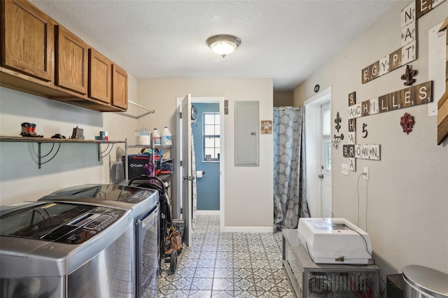 kitchen with electric panel, a textured ceiling, and washing machine and dryer