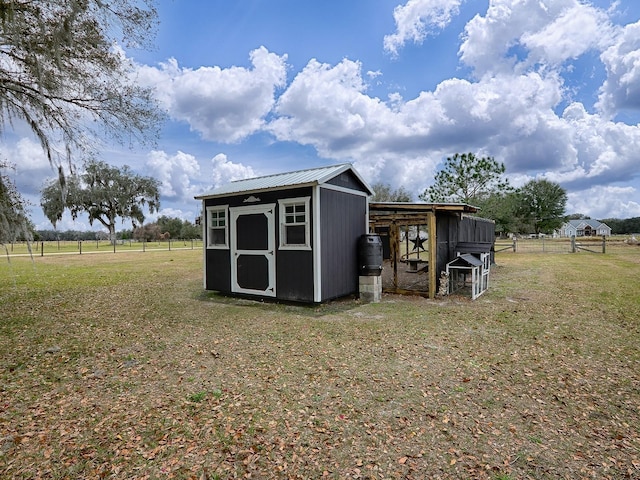 view of outbuilding featuring a yard and a rural view