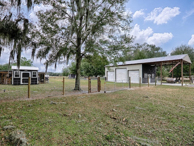 view of yard with a garage and an outbuilding