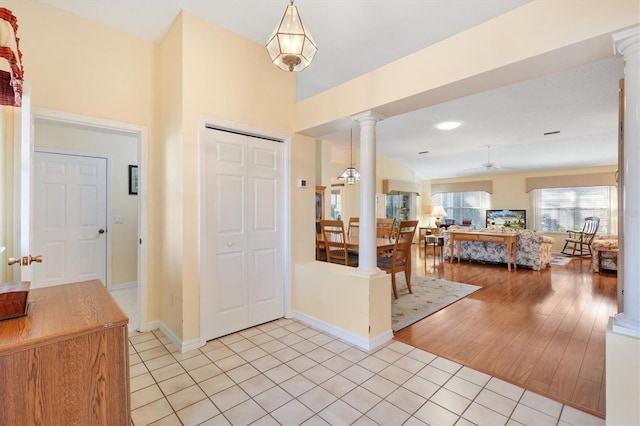 tiled foyer featuring lofted ceiling, decorative columns, and ceiling fan