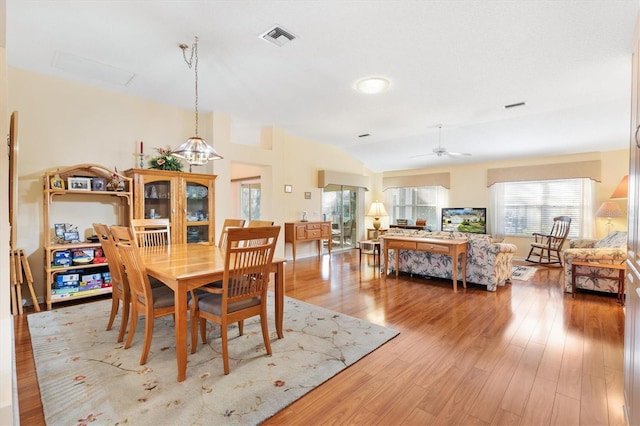 dining room with ceiling fan, vaulted ceiling, and wood-type flooring