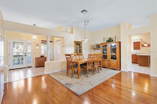 dining room with ornate columns and light wood-type flooring