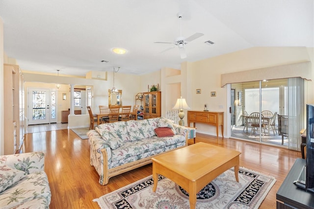 living room with ceiling fan, light hardwood / wood-style floors, and lofted ceiling