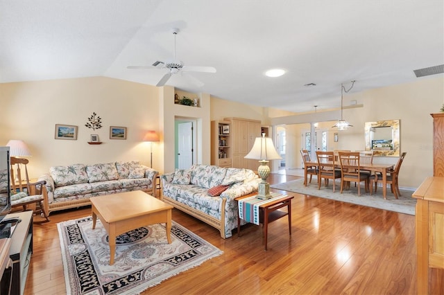 living room with ceiling fan, light wood-type flooring, and lofted ceiling